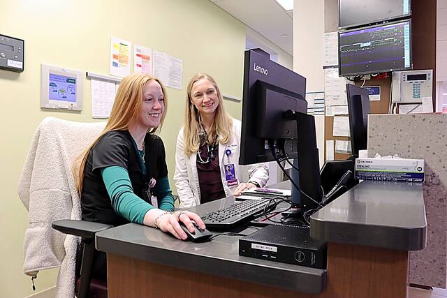 Floor Nurse Lindsey Leljedal, R.N., checks a patient chart with Hospitalist Dr. Jill Kruse, M.D., while working on the inpatient care unit at Brookings Hospital. (Brookings Health System photo)