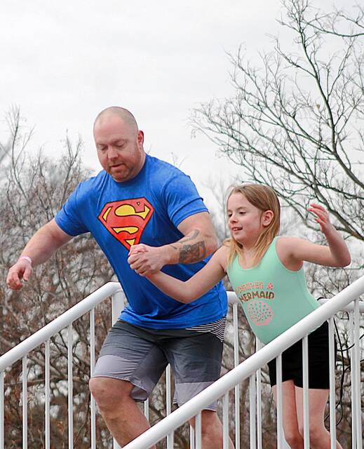 Taking the plunge in support of Special Olympics South Dakota are Super Dad Matt Yonkers and his daughter, Iea, 8, from Aurora. They joined 20 other participants in the annual Polar Plunge on March 14 at Hillcrest Elementary School that brought local law enforcement and community members from across the Brookings area in support of Special Olympics. (John Kubal/Brookings Register)