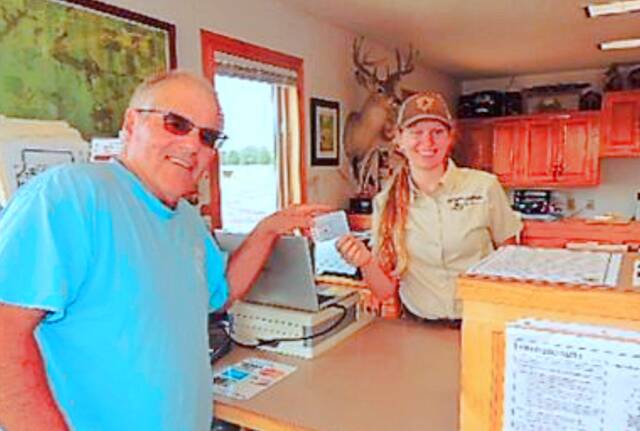 Ava Brenner, SDSU student and intern at Oakwood Lakes State Park, sells a park pass to BWF member Chuck Berry.