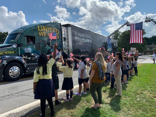Children greet The Wall That Heals truck trailer as it passes through a community.
Photo courtesy Vietnam Veterans Memorial Fund